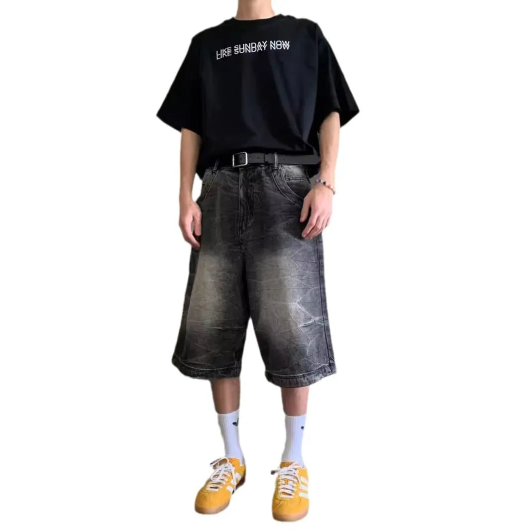Man wearing loose-fit light blue washed denim shorts with a straight leg and cropped length.