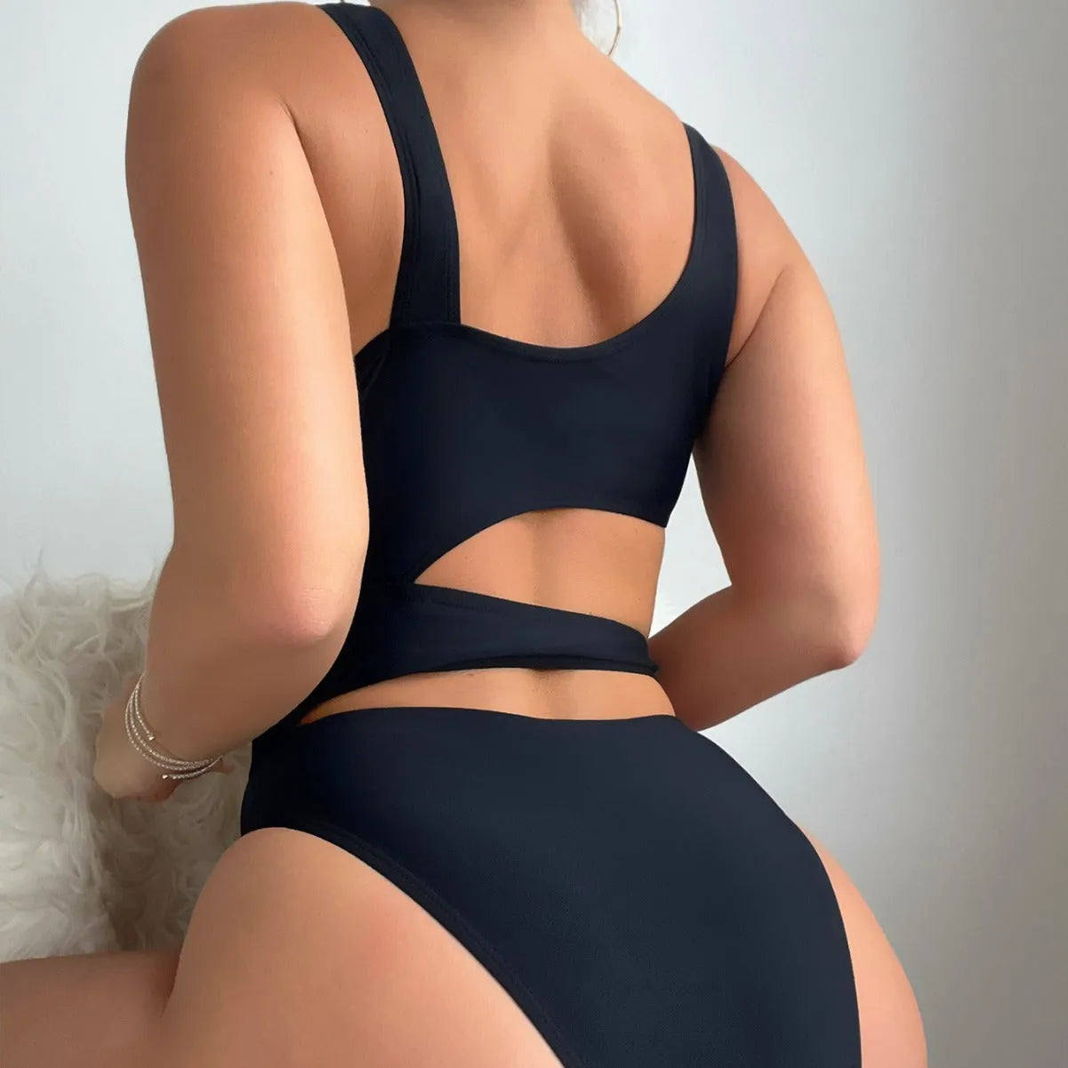 Black solid colour women's one-piece swimsuit with a high cut Siamese style and sleeveless design.