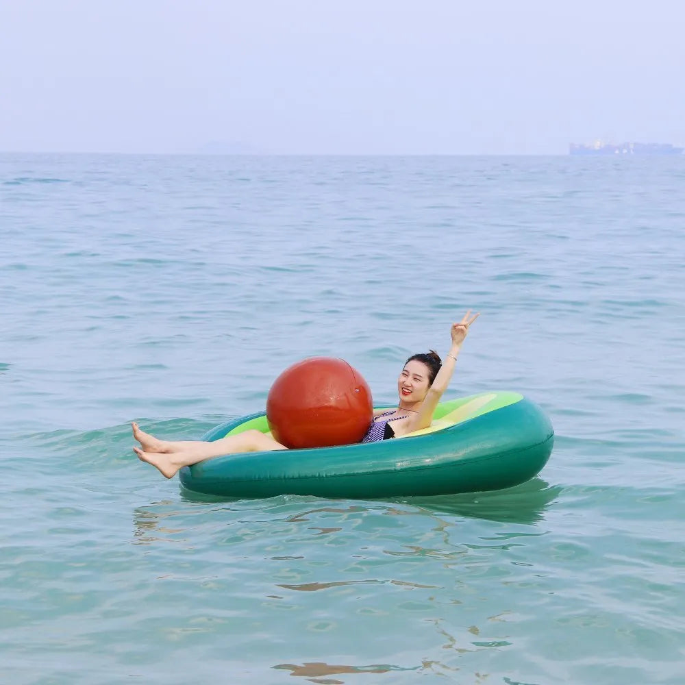 Green inflatable giant avocado pool float on water, showing its large 169x130cm size and smooth surface.