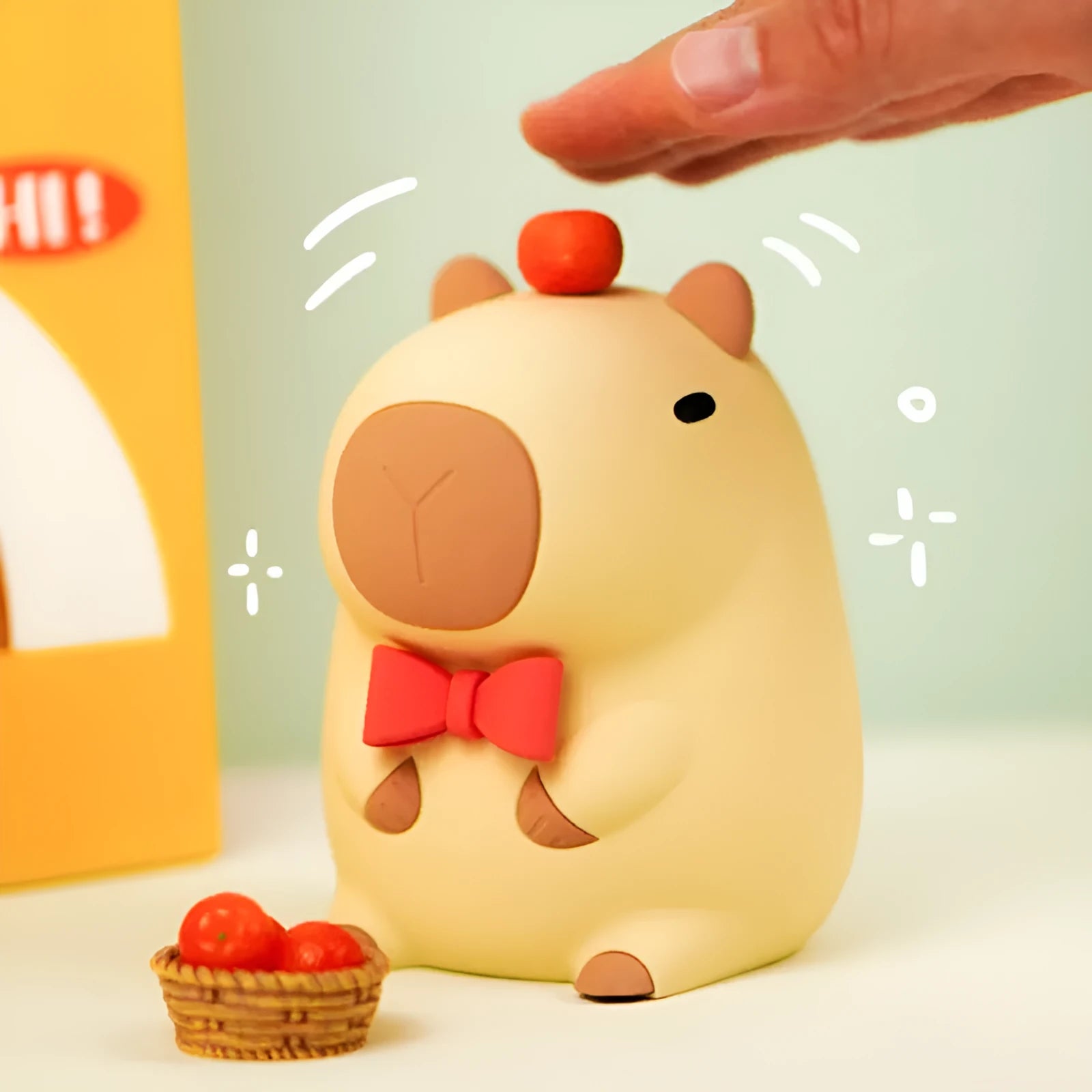 Small capybara-shaped night lamp in silicone and plastic, shown with USB cable.