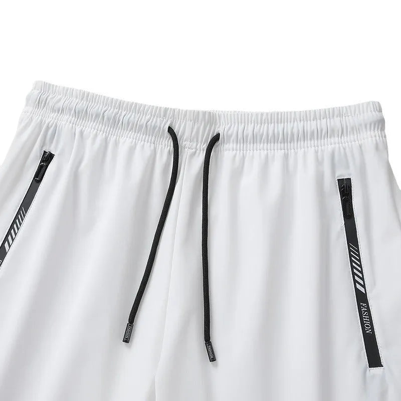 Men's black loose-fit quick-dry nylon sports shorts on a grey background.