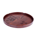 Wooden shallow plate with carved hollow cherry blossom pattern, shown from above.