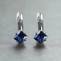 A pair of simple copper earrings with a diamond design created from inlaid zircon stones.