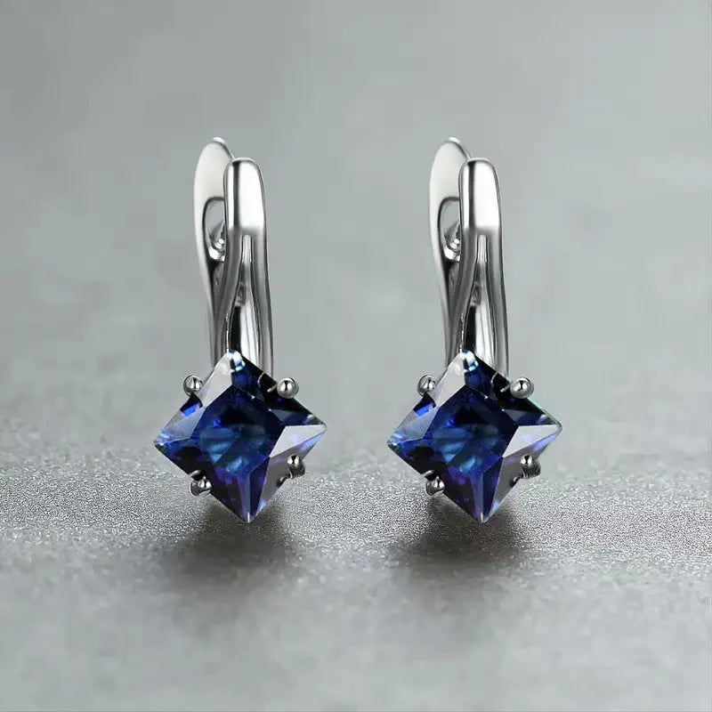 A pair of simple copper earrings with a diamond design created from inlaid zircon stones.