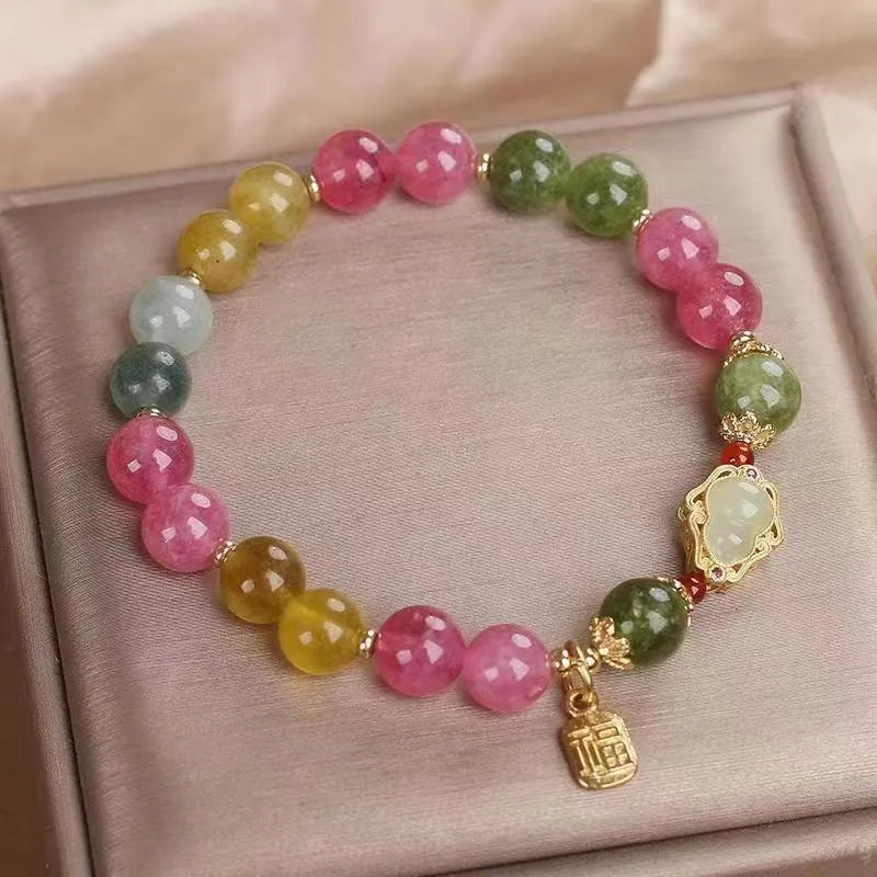 Close-up of a women's gourd blessing card bracelet with colourful tourmaline stones and electroplated finish.