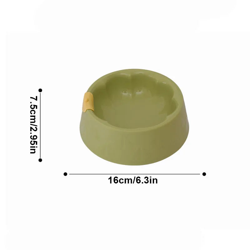 Green flower-shaped plastic double bowl for cat or small dog food and water on a plain surface.