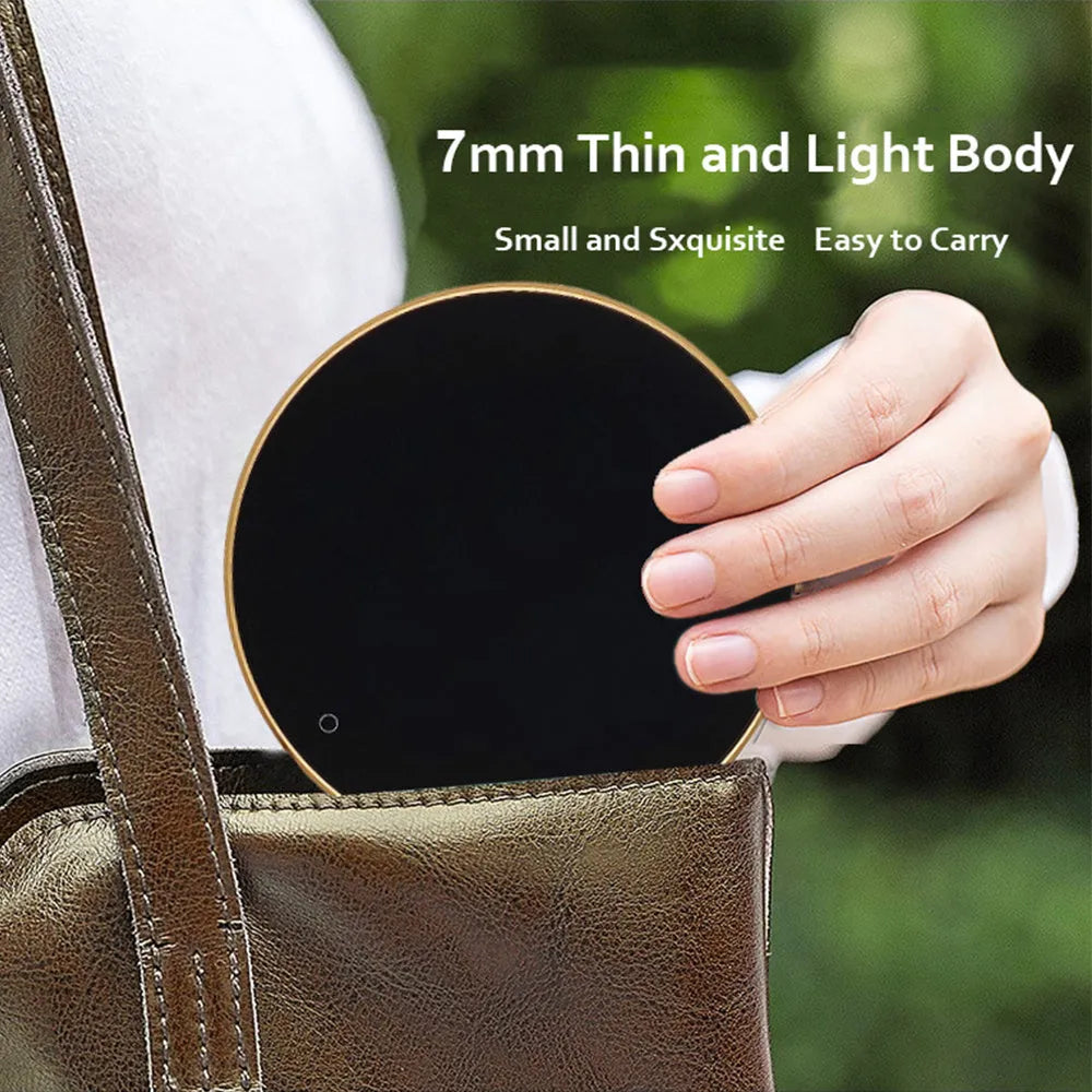 Black USB-powered beverage heating coaster with touch control and coloured LED lights on a wooden desk.