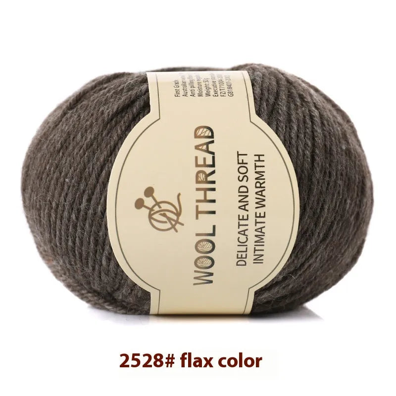 One roll of beige domestic wool hand-knitting yarn for size 10 needles next to knitting needles.