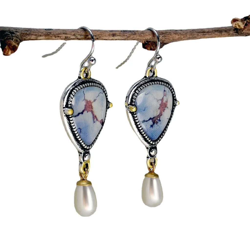 Retro blue drop earrings with synthetic blue opal and white pearl on a geometric metal setting.