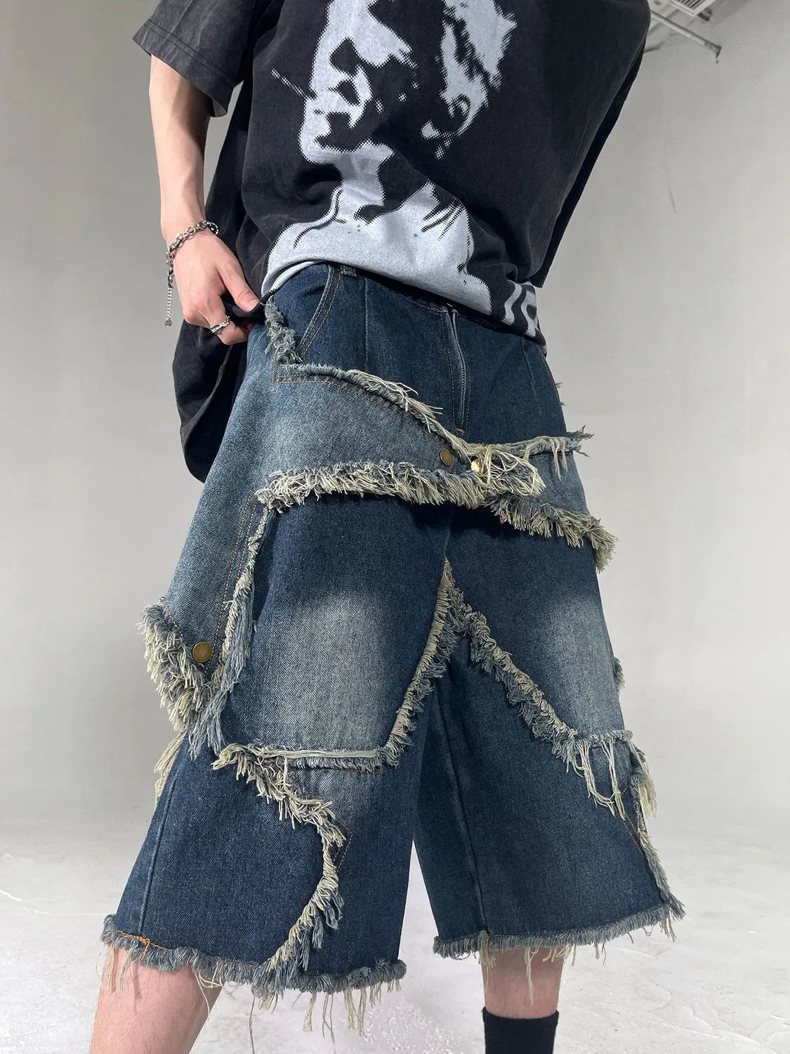 Blue denim shorts with frayed five-pointed star design detail, loose fit cut for summer casual wear
