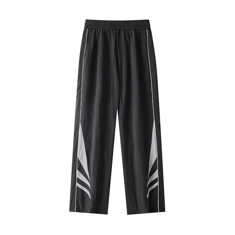 A man wearing black straight-leg loose-fit casual sports trousers for summer.
