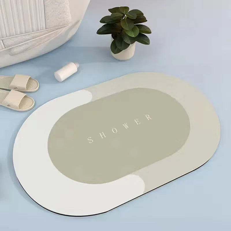 Oval grey polyester door mat with textured rubber non-slip backing on a wooden floor.