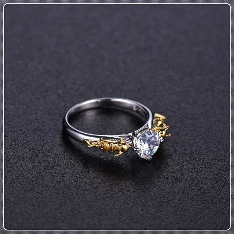 Copper crown model ring with black gold finish on a plain background, showing detailed peaks and band.