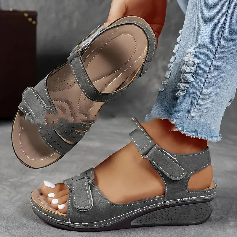 Women's beige thick-soled sandals with adjustable black Velcro straps on a white background.