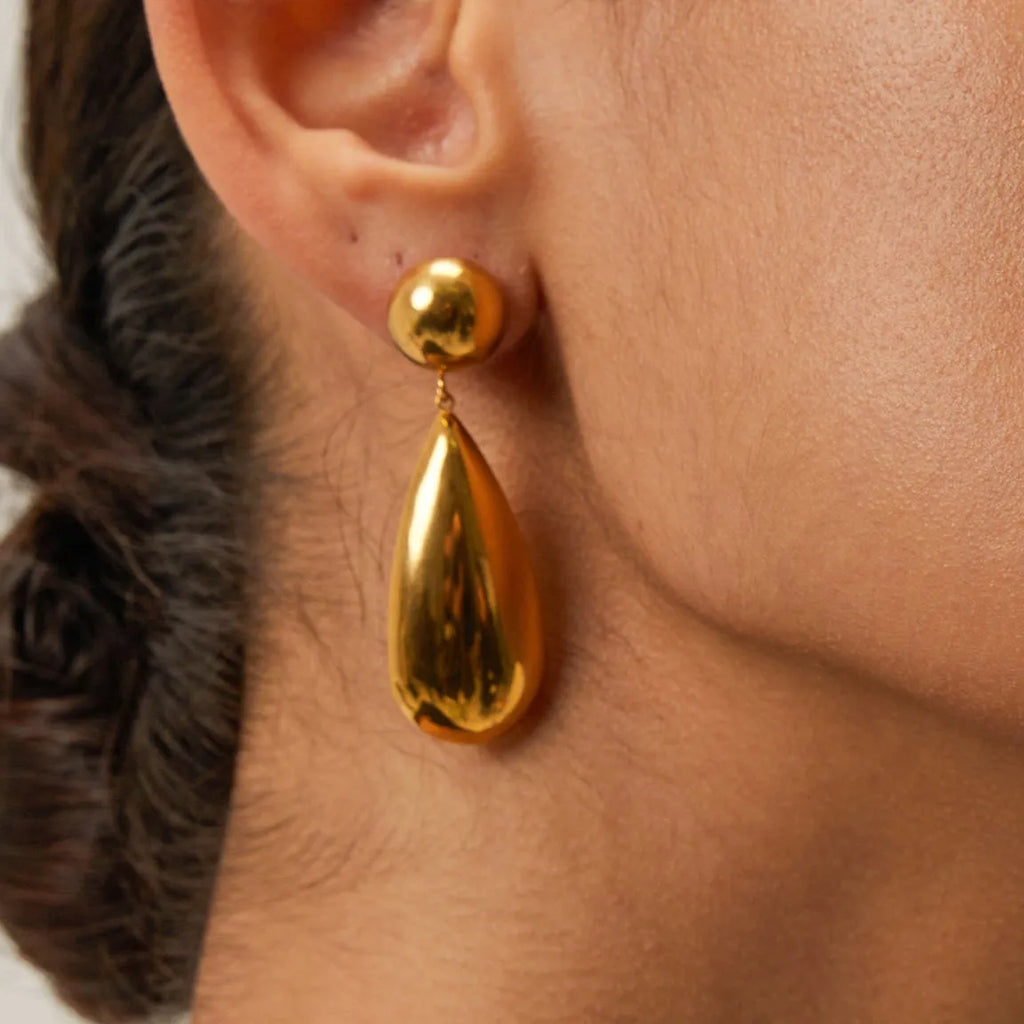 Gold stainless steel earrings with a geometric hemisphere and dangling water droplet pendant.