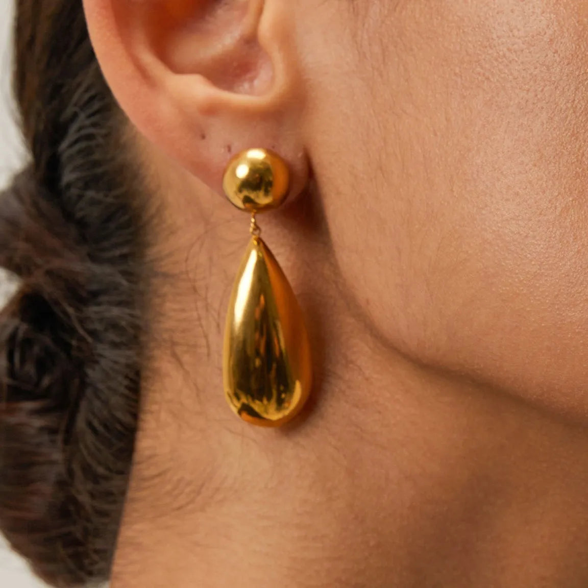 Gold stainless steel earrings with a geometric hemisphere and dangling water droplet pendant.