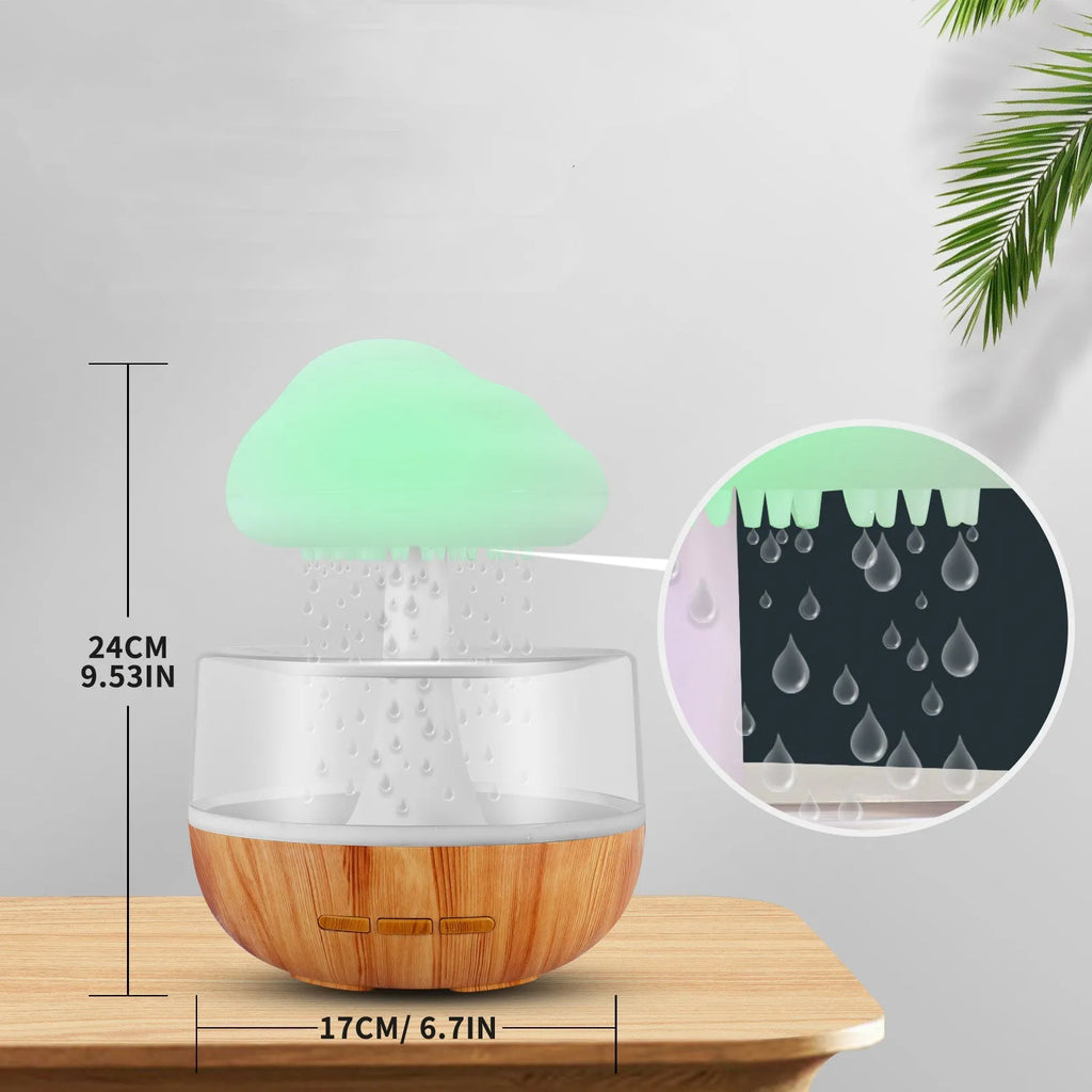 White cloud-shaped ultrasonic humidifier with coloured LED night light on a table.