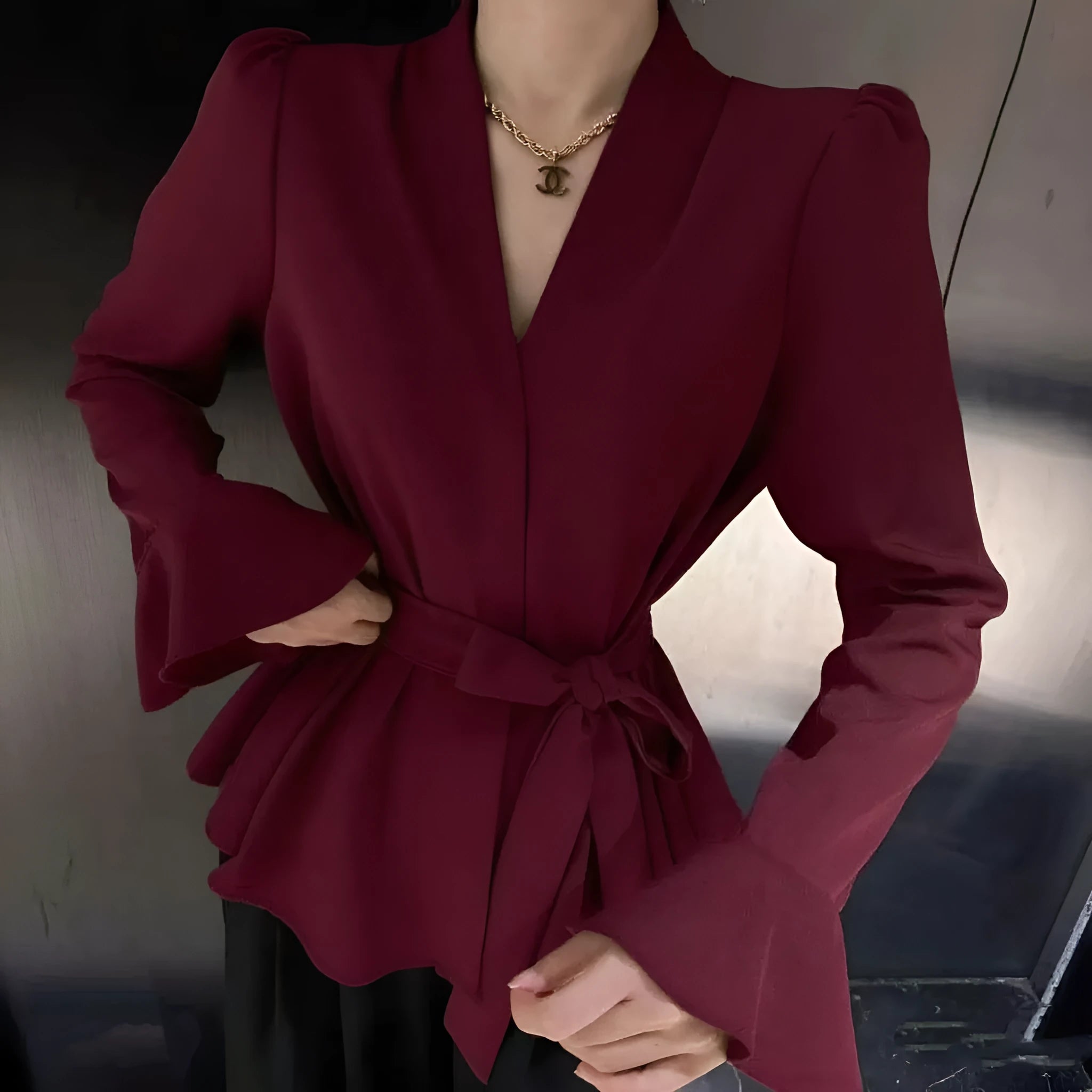 Women's black French-style long sleeve shirt with irregular collar, bell sleeves, and a tied front.