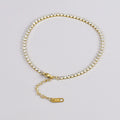 Gold titanium steel anklet with small fruit-shaped pendant and adjustable tail chain on bare ankle