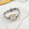 Oval women's fashion watch on wrist showing 9mm thick case, available in black gold, platinum and other colours.