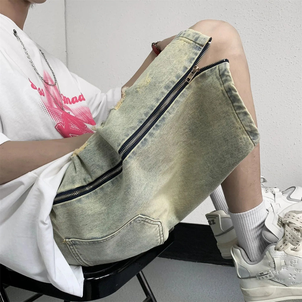 Men's blue denim shorts with yellow mud finish, ripped details, cardigan buttons, and a straight leg opening.