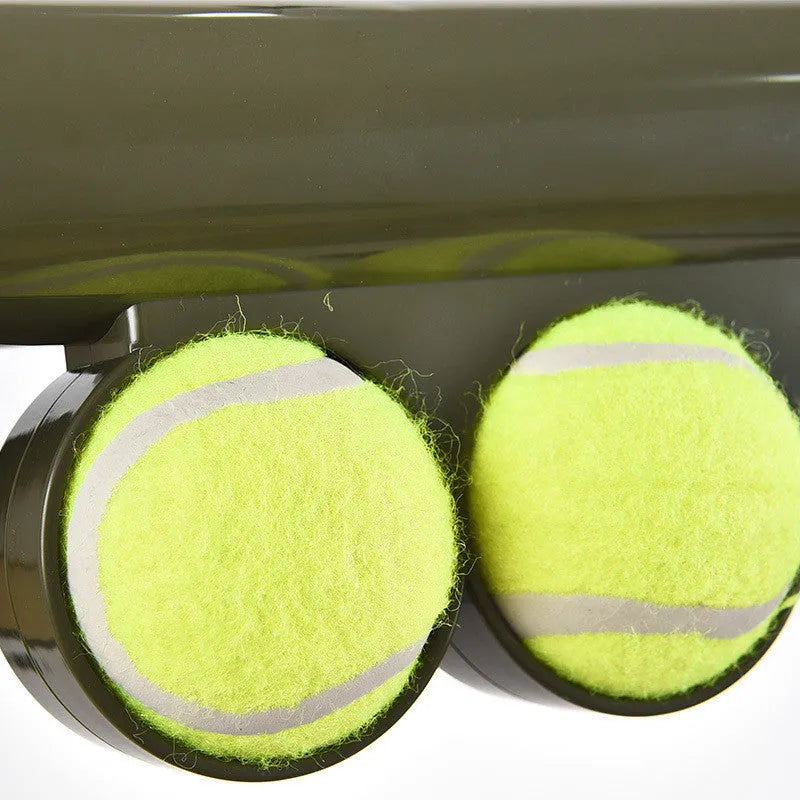 Black ABS plastic tennis ball launcher for dogs with one tennis ball, showing its long 65.5 cm design.