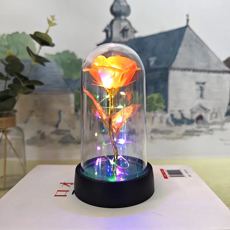 Small decorative night lamp with plastic flowers and a glass-style cover on a black base.