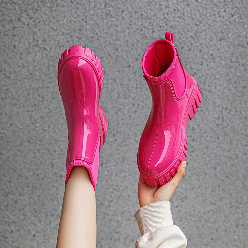 A pair of low tube, flat-heeled PVC rain boots in a solid colour.