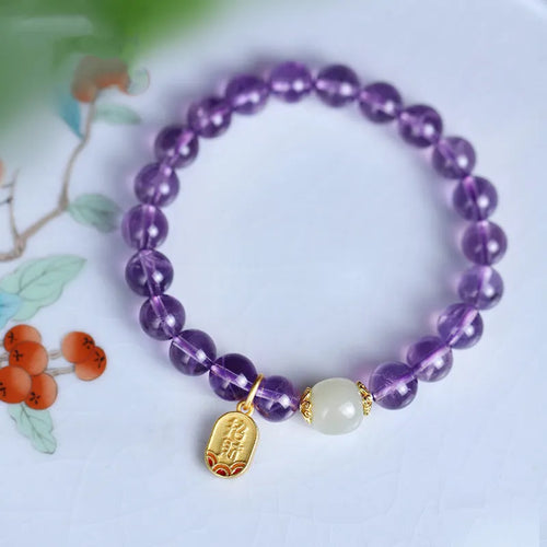 Close-up of a women's amethyst bracelet with 8mm geometric crystal beads on a wrist.