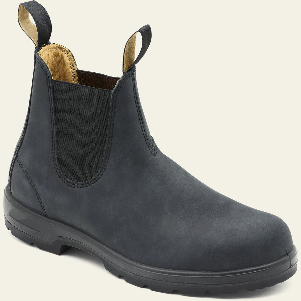 A pair of vintage-style brown Chelsea boots with a round toe and low heel on a wooden floor.