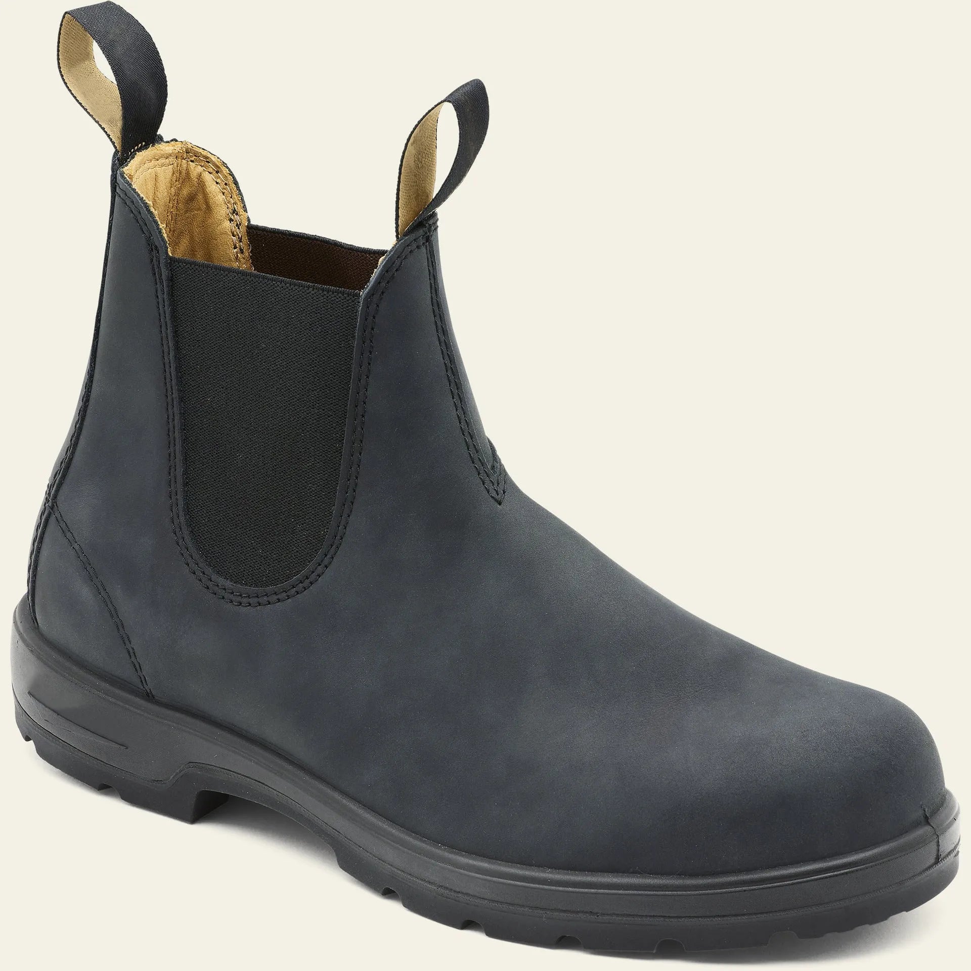 A pair of vintage-style brown Chelsea boots with a round toe and low heel on a wooden floor.