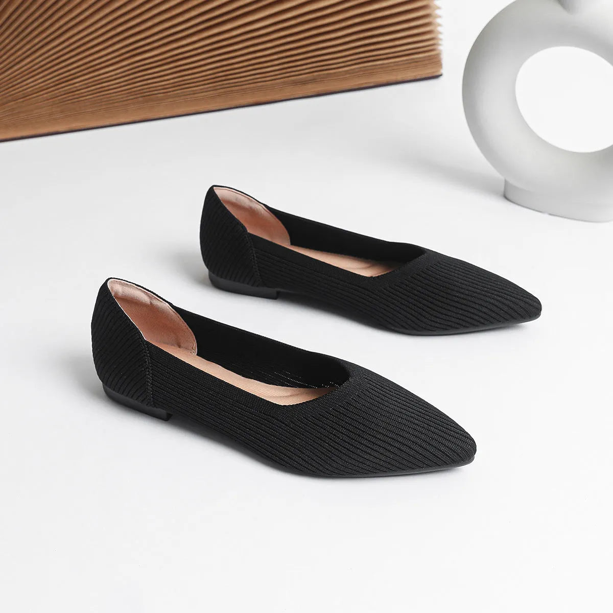 Women's apricot-coloured knit flat pumps with a pointed toe and slip-on design on a white background.