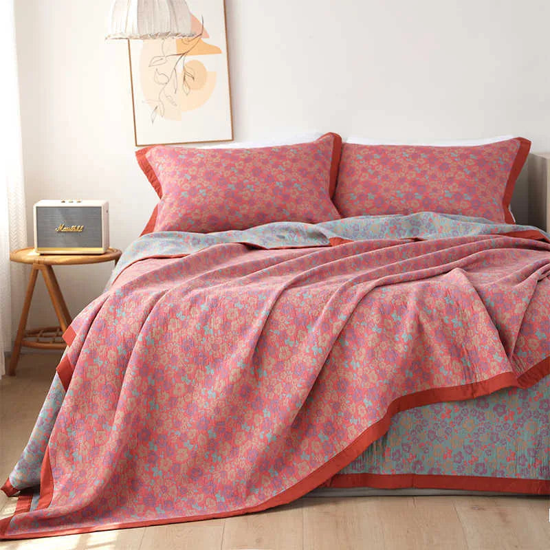 Three-piece cotton gauze bed set with floral plants and flowers pattern, showing blanket and pillowcases.