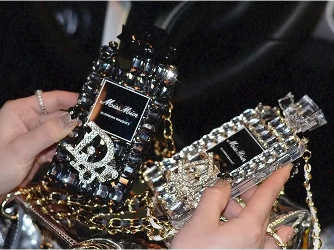 Perfume bottle design iPhone case with metal chain strap in black, shown on an iPhone.