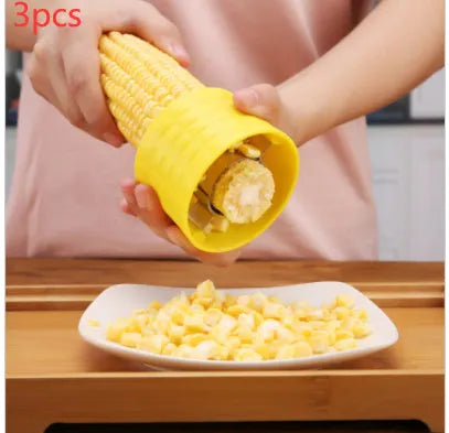 Yellow corn-shaped manual thresher with PP plastic body and stainless steel gear for removing kernels from corn cobs.