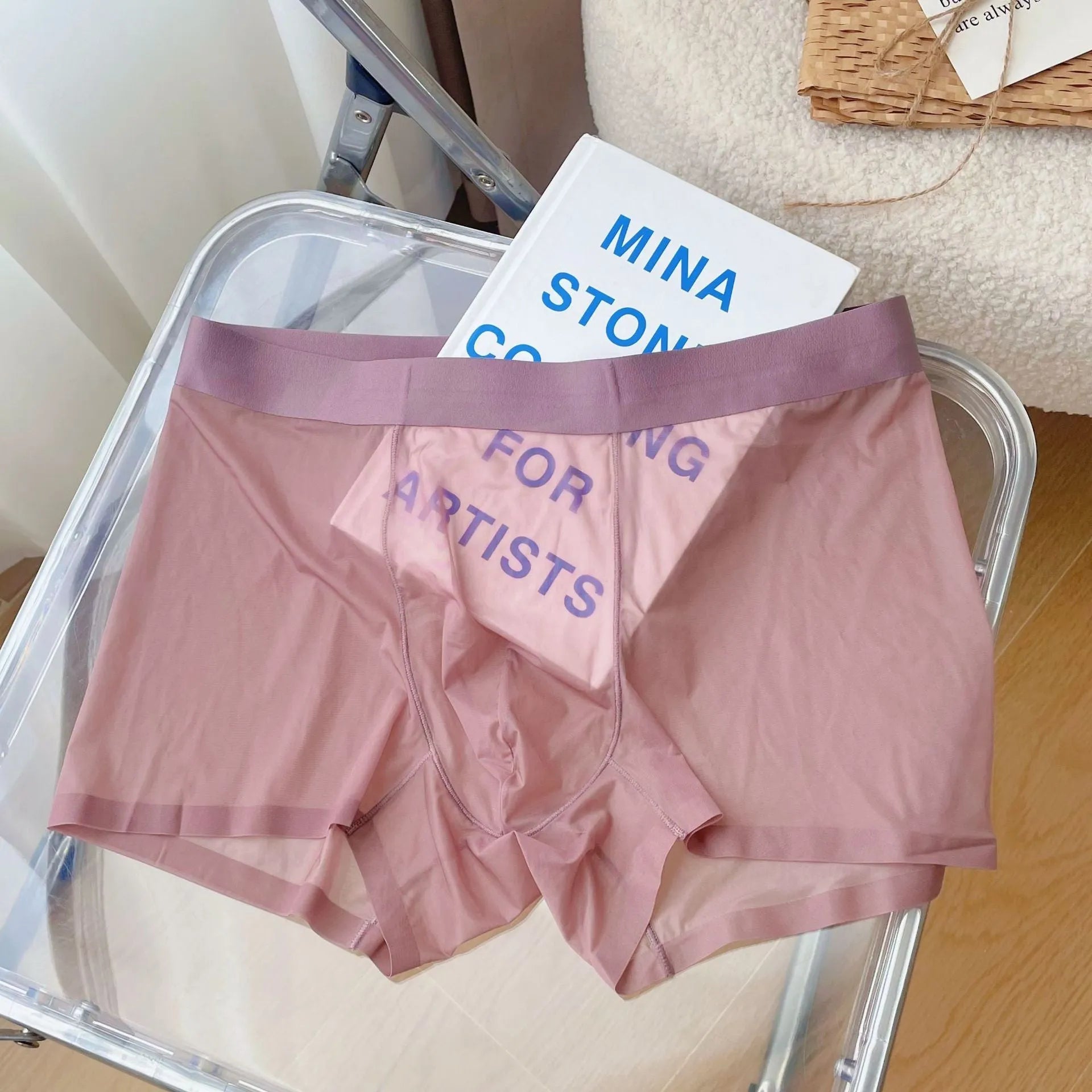Man wearing thin grey seamless nylon boxer shorts with a mid-waist design.