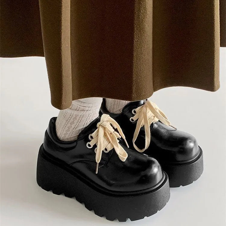 Matte black women's lace-up heels with a thick sole and round toe.