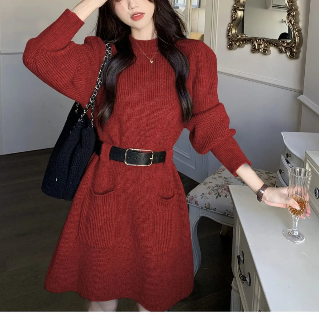 Women's beige long sleeve loose knit dress with a black belt on a hanger.