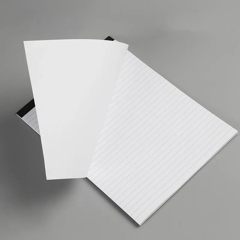 A4 tearable grid notebook with a paper cover, lying open to show ivory pages and wireless binding.
