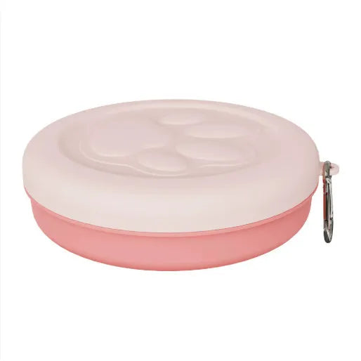 Collapsible silicone dog bowl in light pink, shown both folded flat and popped open, with separate lid next to it.