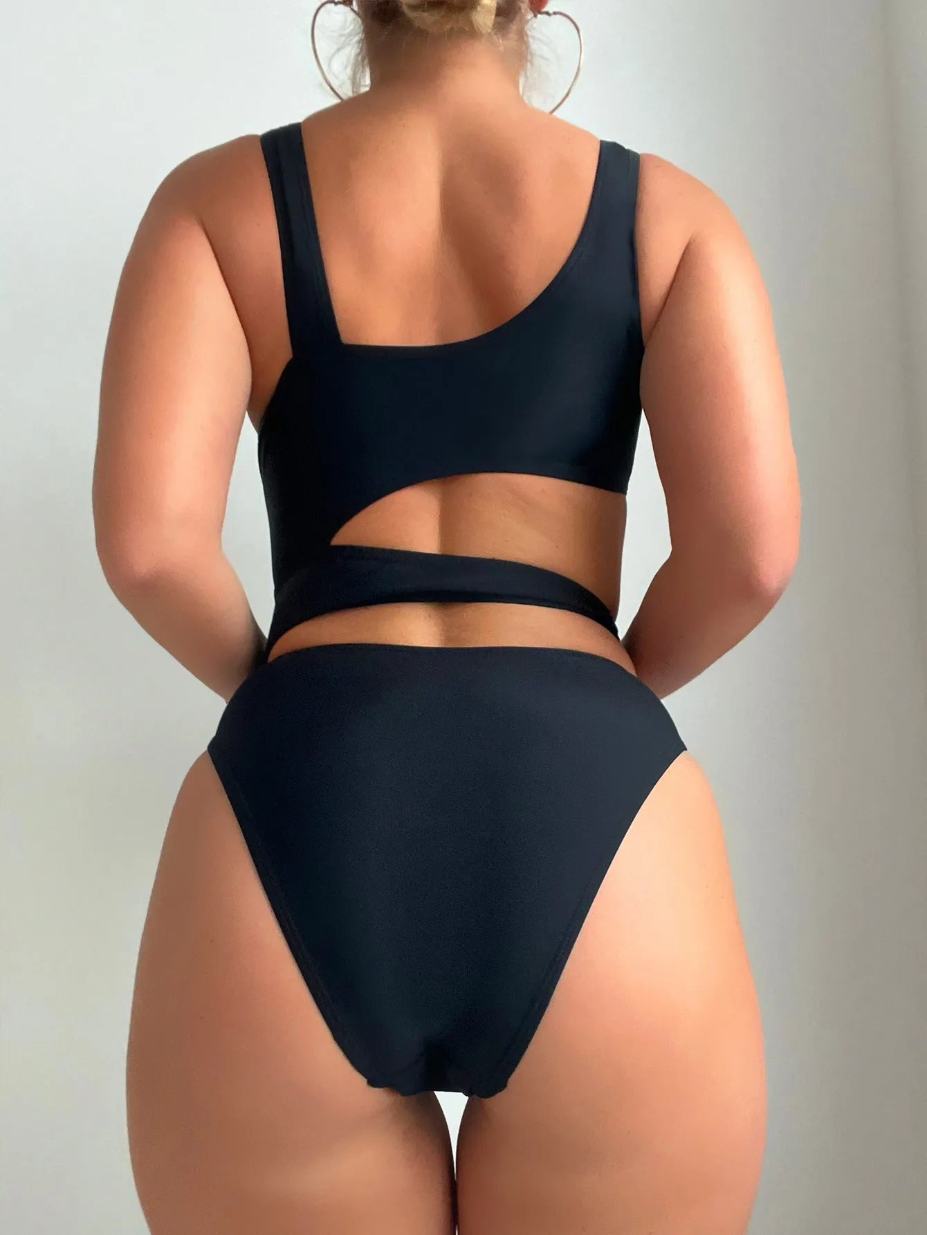 Black solid colour women's one-piece swimsuit with a high cut Siamese style and sleeveless design.
