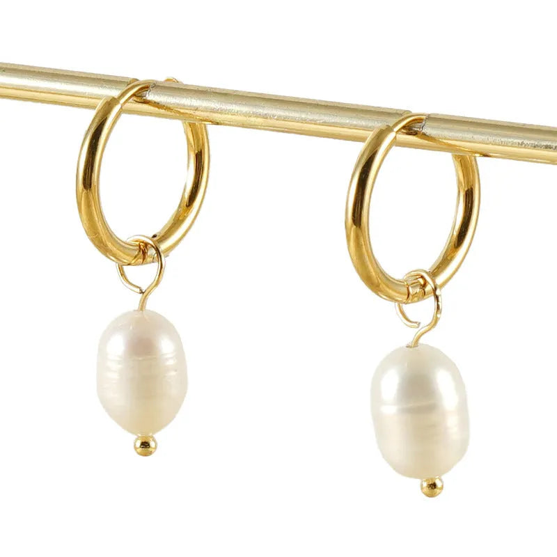 A pair of gold geometric-shaped stainless steel earrings featuring a central pearl and titanium steel posts.