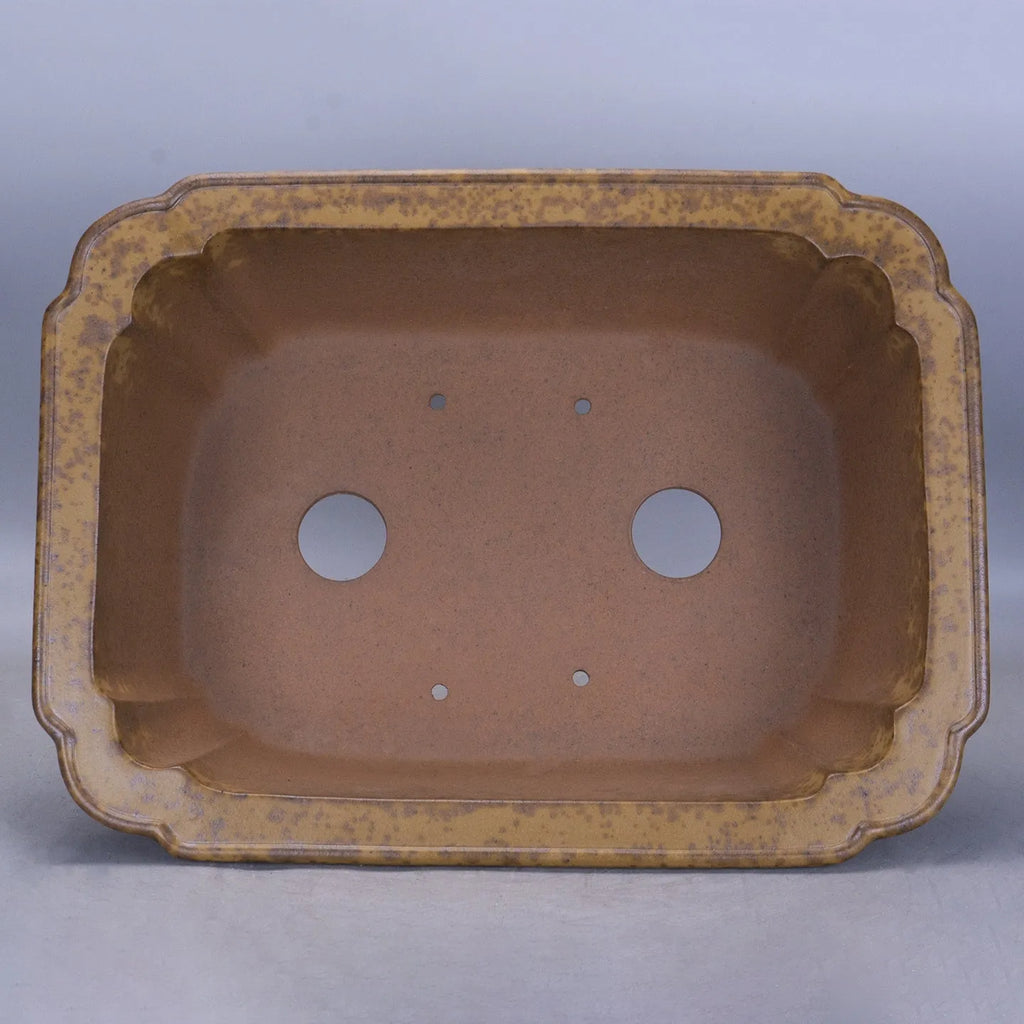 Hand-thrown rectangular purple sand flower pot with dual drainage holes on a wooden deck.