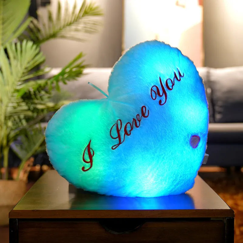 Colourful glowing five-pointed star plush pillow on a dark background, showing soft texture and LED illumination