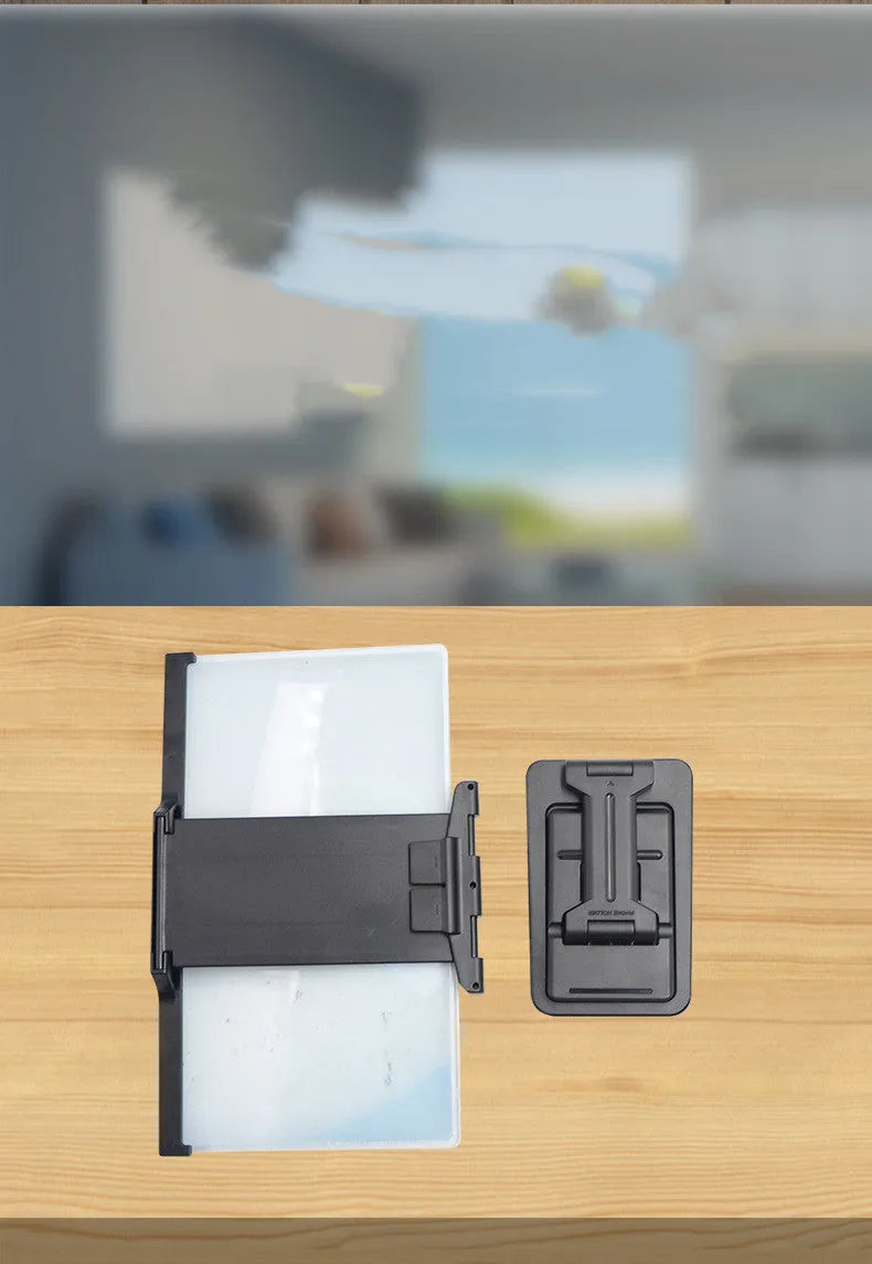 Black foldable mobile phone screen magnifier with detachable shading holder on a desktop.