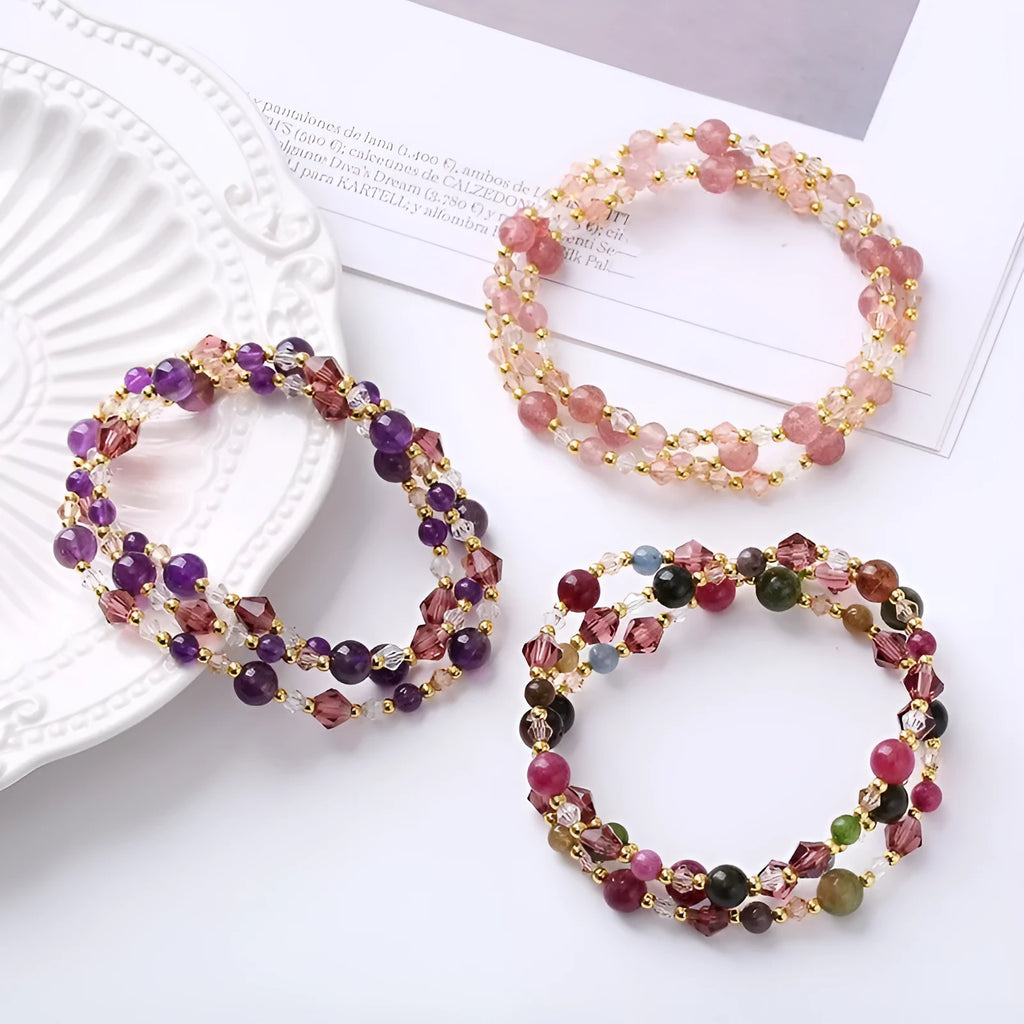 Women's three-ring crystal bracelet with tourmaline, strawberry quartz, and amethyst stones on adjustable rope