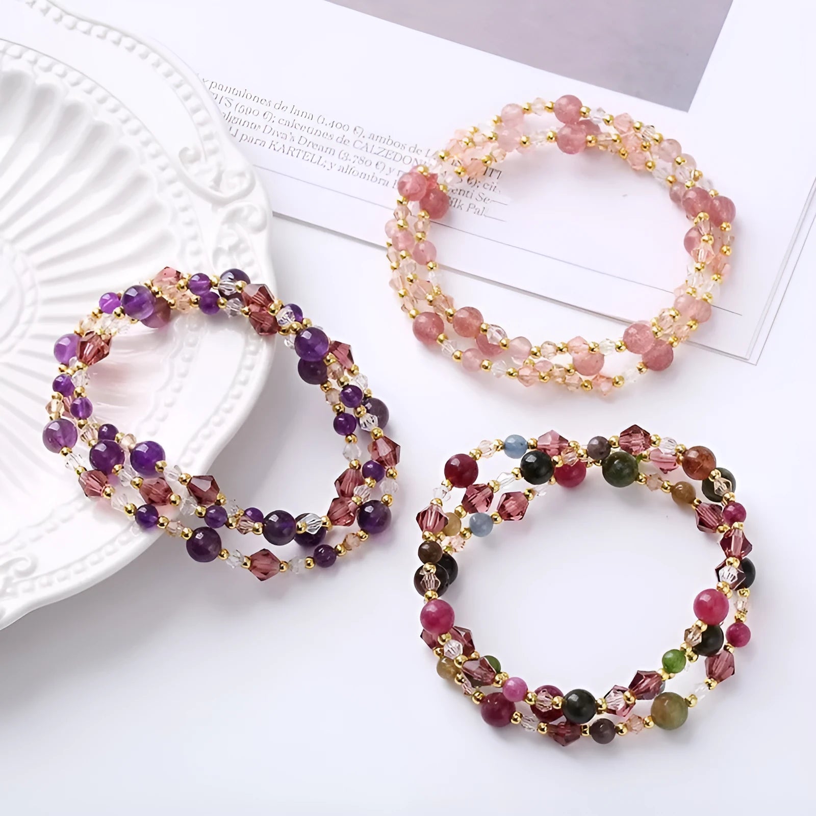 Women's three-ring crystal bracelet with tourmaline, strawberry quartz, and amethyst stones on adjustable rope