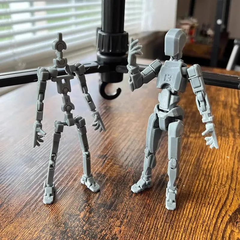 3D printed multi-jointed robot action figure model with movable joints on a desk.