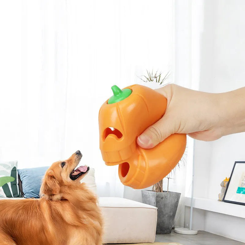 Orange Halloween pumpkin shaped rubber dog toy with a treat-dispensing funnel hole.