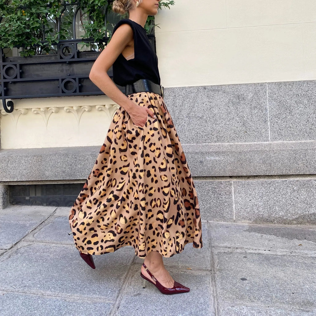 Brown leopard print women's A-line long skirt with a wide flowing hem on a model.